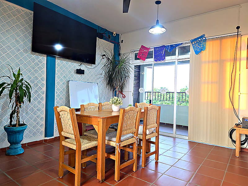 La sala de juntas del coworking, con mesa para seis, pantalla y pizarrón
